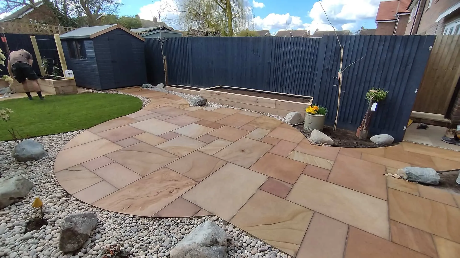 Circular Indian sandstone patio and lawn in a new-build garden in Ringmer